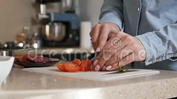 女孩用刀切下一个成熟多汁的西红柿切新鲜蔬菜做披萨视频的预览图