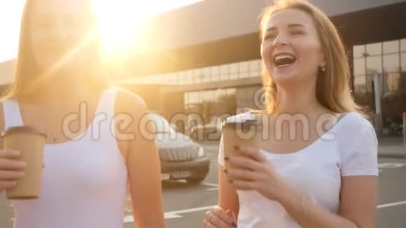 4k视频两位笑眯眯的女朋友在街上散步时玩得开心喝咖啡视频的预览图