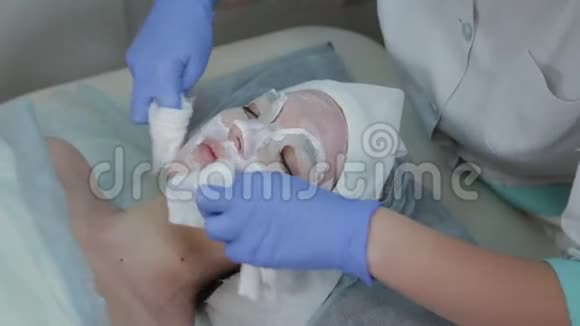 专业美容师女性用湿巾从客户的脸上摘下面具视频的预览图