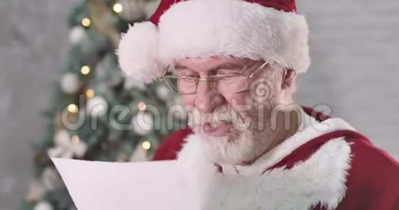 特写圣诞老人读信做不悦的脸一位留着白胡子的老人在想礼物视频的预览图