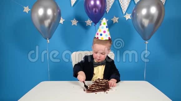 男孩在生日桌上吃巧克力蛋糕这是聚会和生日的概念视频的预览图