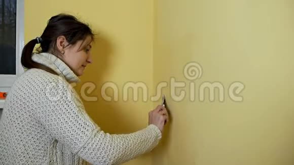 女孩在画之前把房间里的黄墙吐出来DIY修理把关节绑起来年轻女子穿上视频的预览图