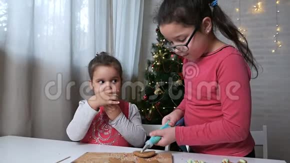 两个可爱的小女孩女孩们在美丽的圣诞节的背景下为圣诞节准备姜饼视频的预览图