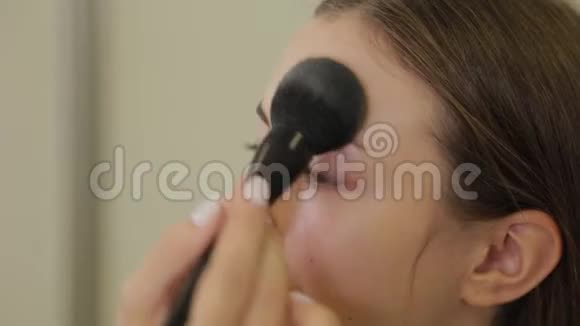 专业化妆师正在用刷子客户的脸上涂粉视频的预览图