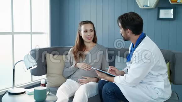 微笑的孕妇在产前诊所和医生交谈视频的预览图