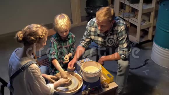 动作慢女人教男人和男孩用陶轮工作视频的预览图