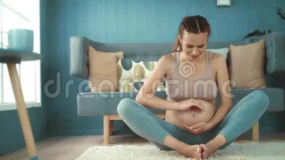 快乐的未来母亲在室内看着相机准妈妈抱着肚子视频的预览图