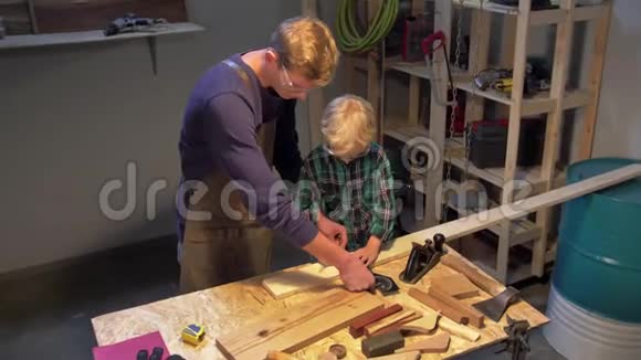 男人教男孩如何在车间里测量木板视频的预览图