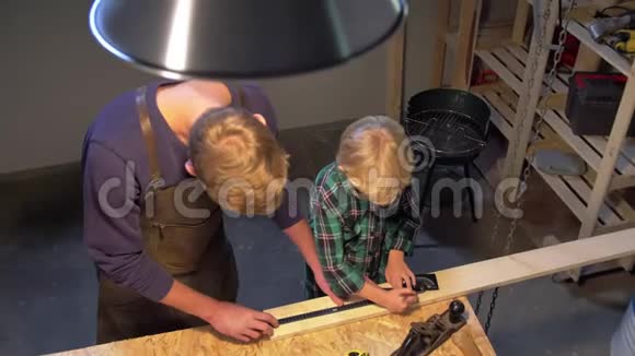 男人和男孩在车间里用木板工作慢动作视频的预览图