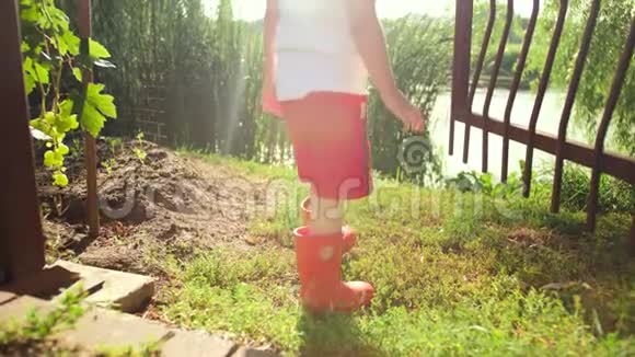 4k视频小男孩穿红色橡胶靴打开了农场的金属大门视频的预览图