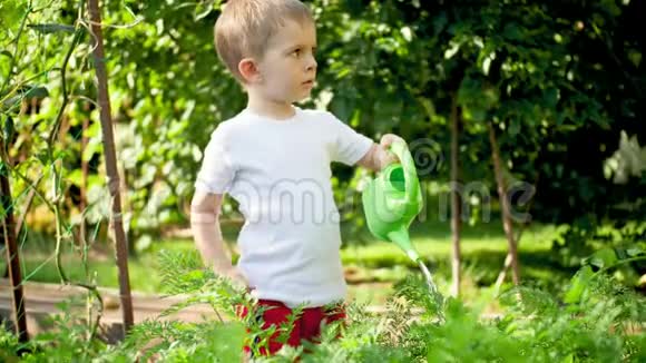 4k视频小4岁男孩用玩具塑料浇水罐给园床浇水视频的预览图
