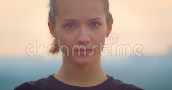 年轻漂亮的运动女性慢跑者穿着黑色T恤看着相机美丽的日落视频的预览图