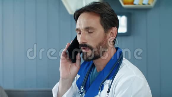 男医生慢动作在医务处讲电话的肖像视频的预览图