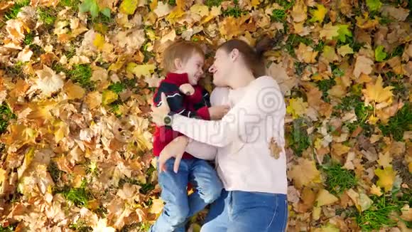 4k视频小学步男孩与母亲玩耍互相挠痒痒拥抱和亲吻而躺在黄色视频的预览图