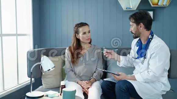 漂亮的孕妇在柜子里的沙发上和医生说话视频的预览图