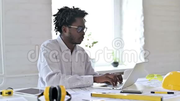 年轻的非洲工程师带着笔记本电脑在办公室里对着摄像机微笑视频的预览图