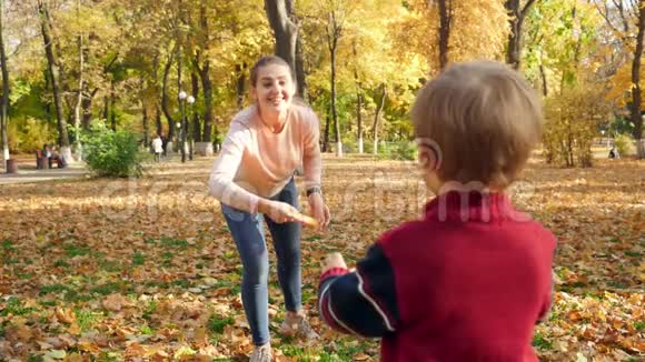小男孩在公园和妈妈玩捉飞盘的慢动作视频视频的预览图