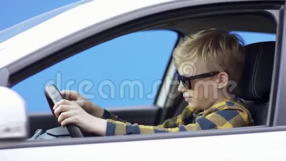 一个穿休闲服装的金发小男孩正在旅行英俊的男孩正在驾驶绿色屏幕背景的汽车他是视频的预览图