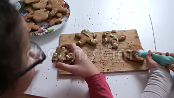 孩子们的手特写为节日装饰姜饼干姜饼图案视频的预览图
