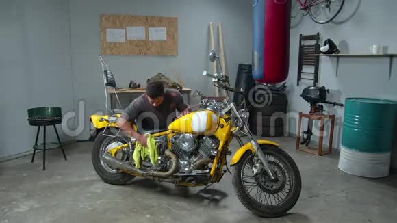 男人在车库里用抹布擦拭摩托车视频的预览图