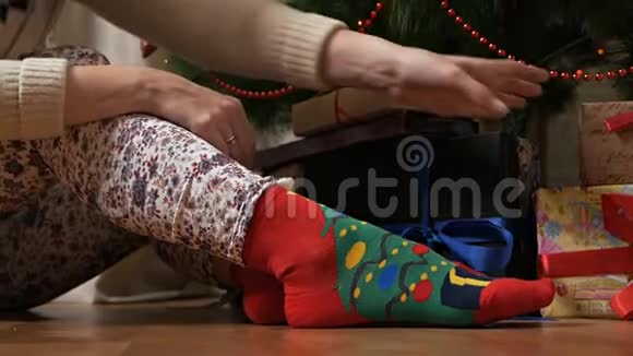 在圣诞树附近穿着圣诞袜的女性腿节日日期圣诞节背景下的女性腿视频的预览图