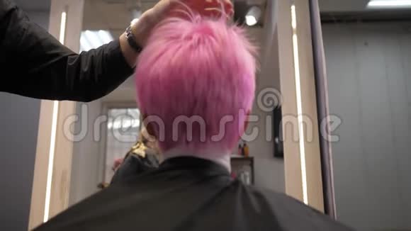 粉红色的短发在发廊里吹干从下面的后视镜慢动作视频的预览图
