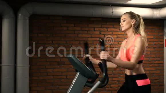 在健身房骑自行车的漂亮女人画像视频的预览图