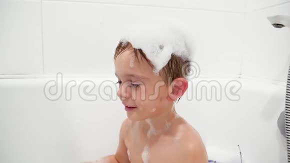 在洗澡的时候可爱的微笑的小男孩挥舞着他的脸揉着眼睛视频的预览图