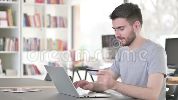 年轻人在网上支付笔记本电脑购物视频的预览图