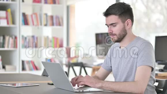 成功的年轻人在办公室用笔记本电脑庆祝视频的预览图
