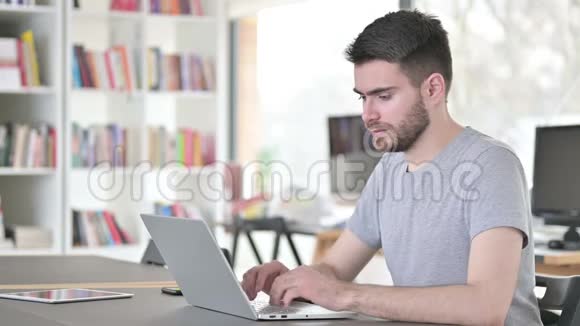 有笔记本电脑的年轻人在办公室里背痛视频的预览图
