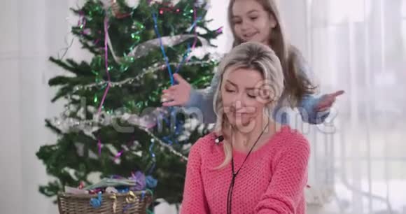 漂亮的黑发白种人女孩用双手闭上的眼睛送给她的圣诞礼物快乐的母亲视频的预览图
