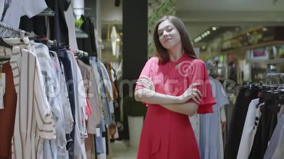 可爱的微笑的女人双臂交叉正在为站在购物中心的相机摆姿势美丽的白种人女孩视频的预览图