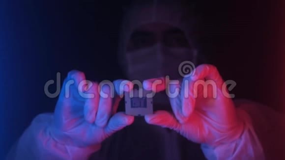 实验室技术员拿着霓虹灯的电脑处理器视频的预览图