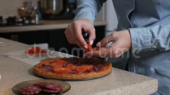 在家做意大利披萨一个女孩把西红柿放在披萨上视频的预览图