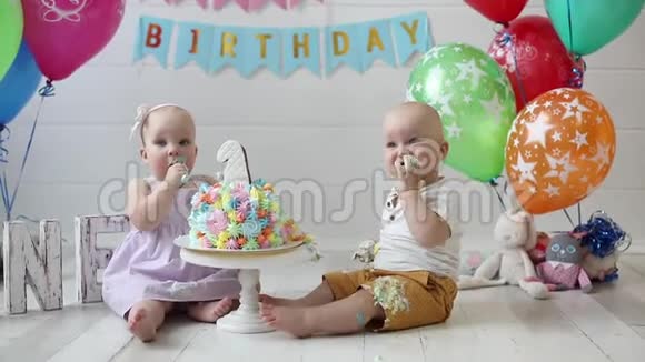 两个可爱的小男孩和女孩在吃节日蛋糕庆祝生日视频的预览图