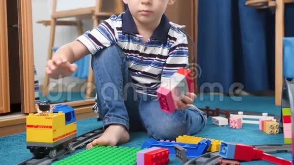4K小男孩玩彩色积木和玩具铁路的镜头视频的预览图