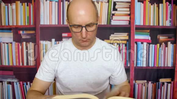 鲍德曼在家书馆的桌子上拿着头读书书架背景视频的预览图