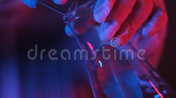 研究人员将白色结晶粉末倒入烧杯中的透明化学液体中视频的预览图