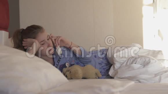 十几岁的女孩躺在旅馆的床上打电话视频的预览图