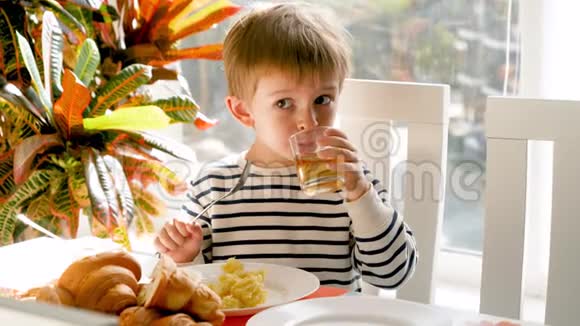 有趣的小男孩在餐厅吃午饭喝汽水或果汁视频的预览图
