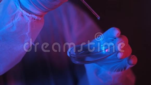 实验室研究人员用霓虹灯将样品从吸管滴入培养皿中视频的预览图