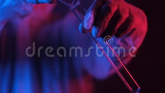 科学家在霓虹灯中用试管慢慢地倒出白色结晶粉末视频的预览图