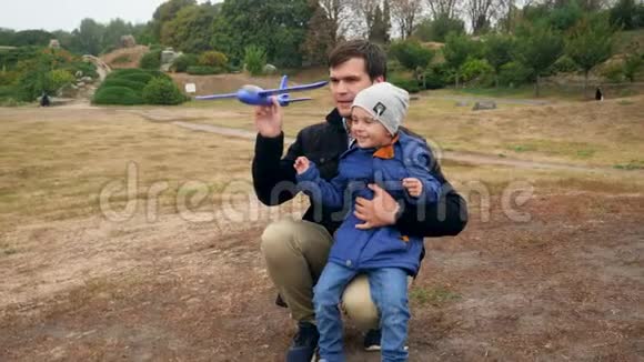 4k视频快乐微笑的小男孩与年轻的父亲发射和玩玩具飞机在公园视频的预览图