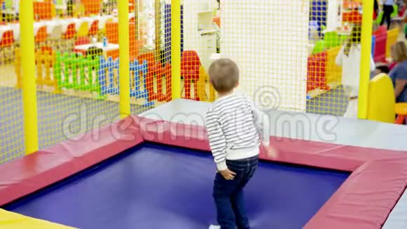 快乐快乐的小男孩在购物中心游乐园蹦床上跳4k视频视频的预览图