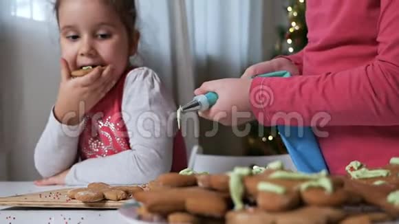 两个可爱的小女孩女孩们在美丽的圣诞节的背景下为圣诞节准备姜饼视频的预览图