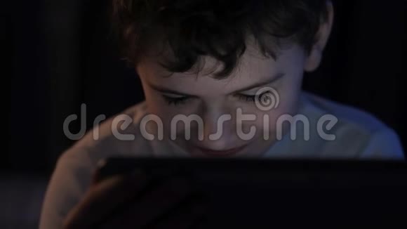 晚上孩子在卧室里看平板电脑上的动画片视频的预览图
