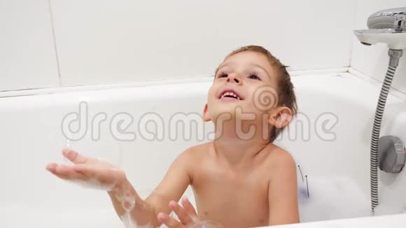 4k慢动作视频快乐的小男孩洗澡玩肥皂泡视频的预览图