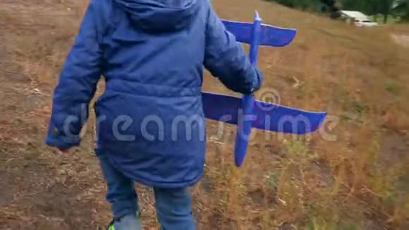 小男孩爬山和在公园发射玩具飞机的慢动作视频视频的预览图