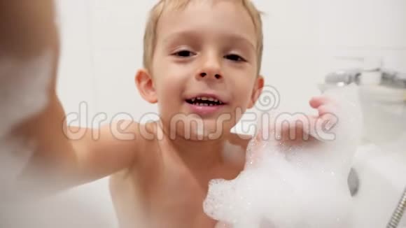 4k视频快乐欢笑的小男孩洗澡时洗满肥皂泡沫和泡泡视频的预览图